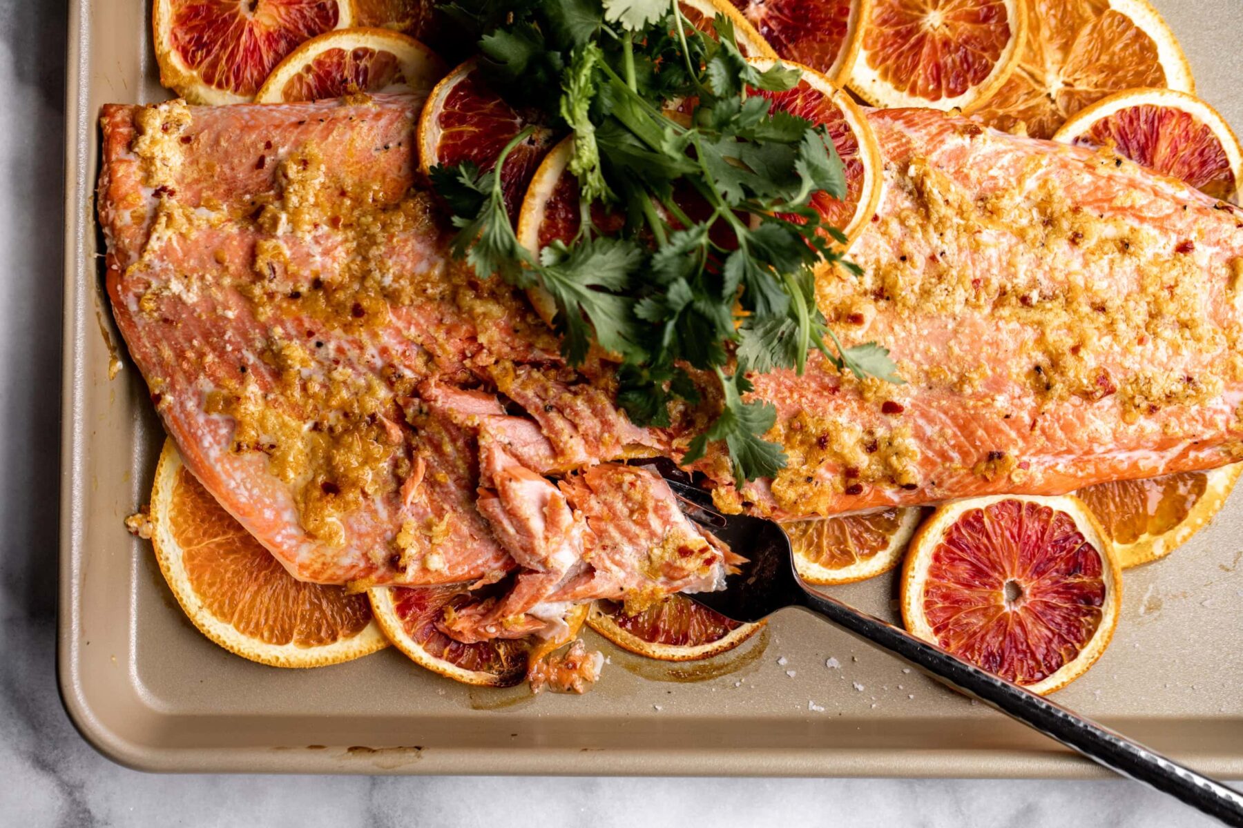 roasted salmon on a sheet pan with sliced oranges and blood oranges.