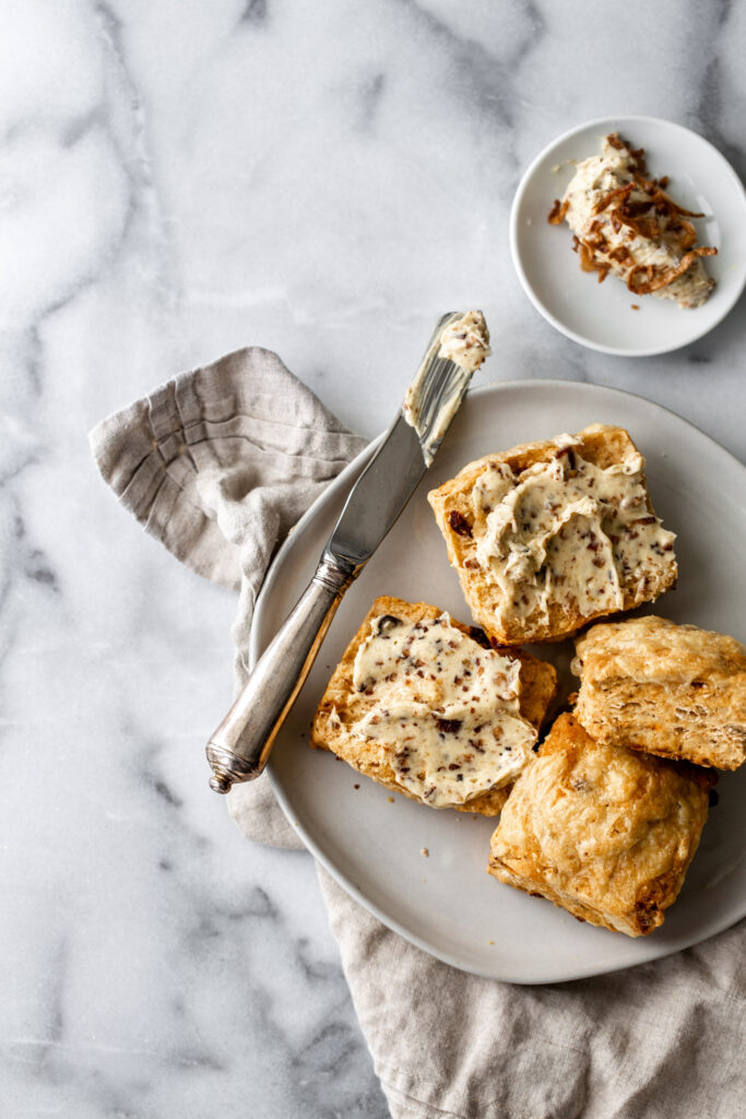 irish soda bread dinner rolls with a knife and shallot butter on marble | How to Style Food Photos