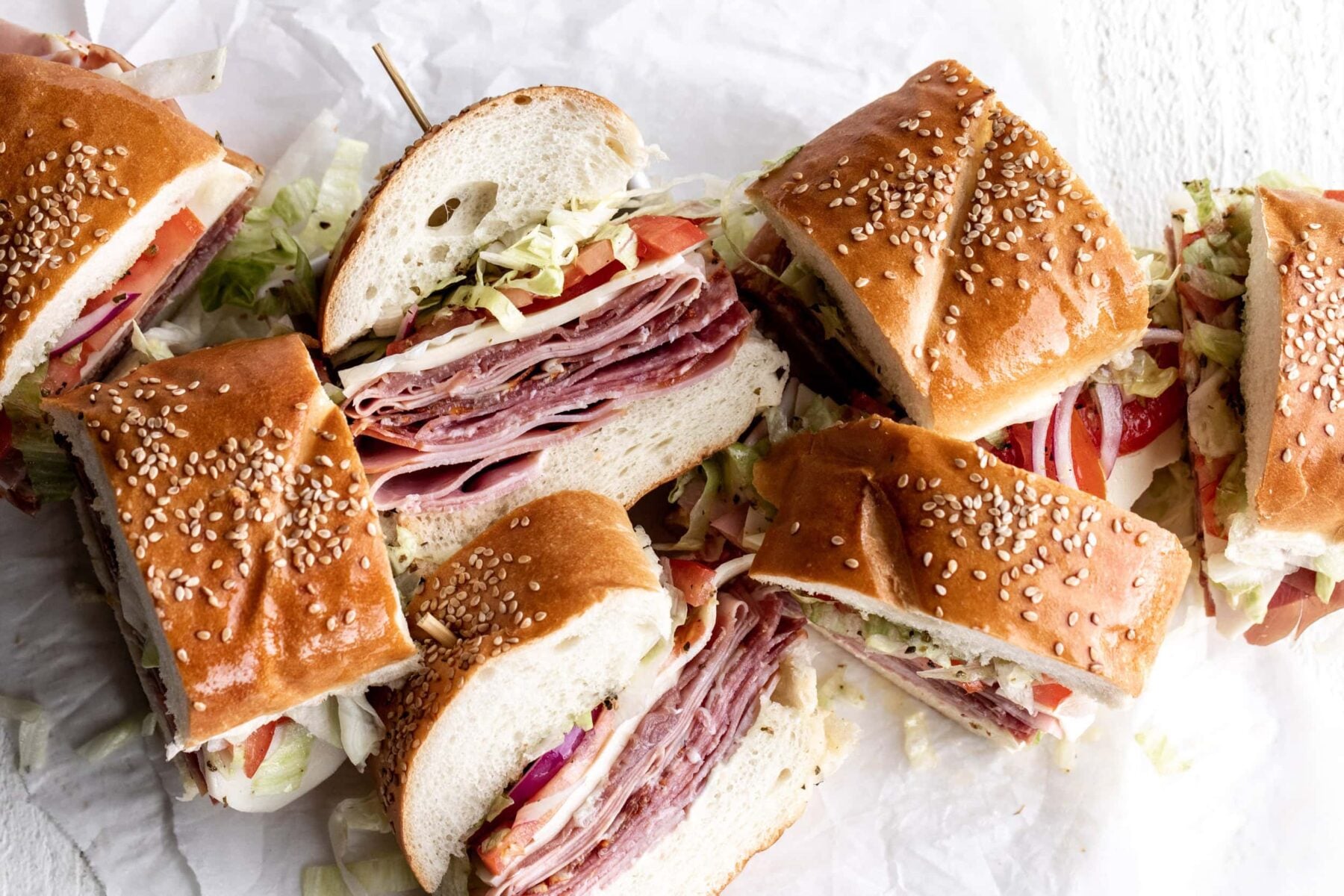 Italian sub sandwich or hoagie with salami, prosciutto, mortadella, ham and capicola with provolone cheese on rolls.