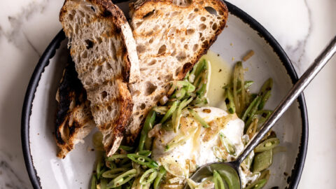 sugar snap peas are thinly sliced on the bias with shallots served over creamy burrata with grilled bread