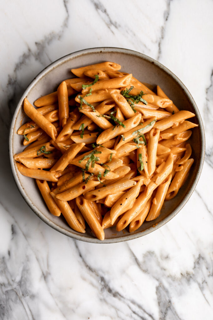 Penne pasta served in creamy tomato vodka sauce with grilled chicken and red pepper flakes for an Italian-American classic, penne alla vodka.