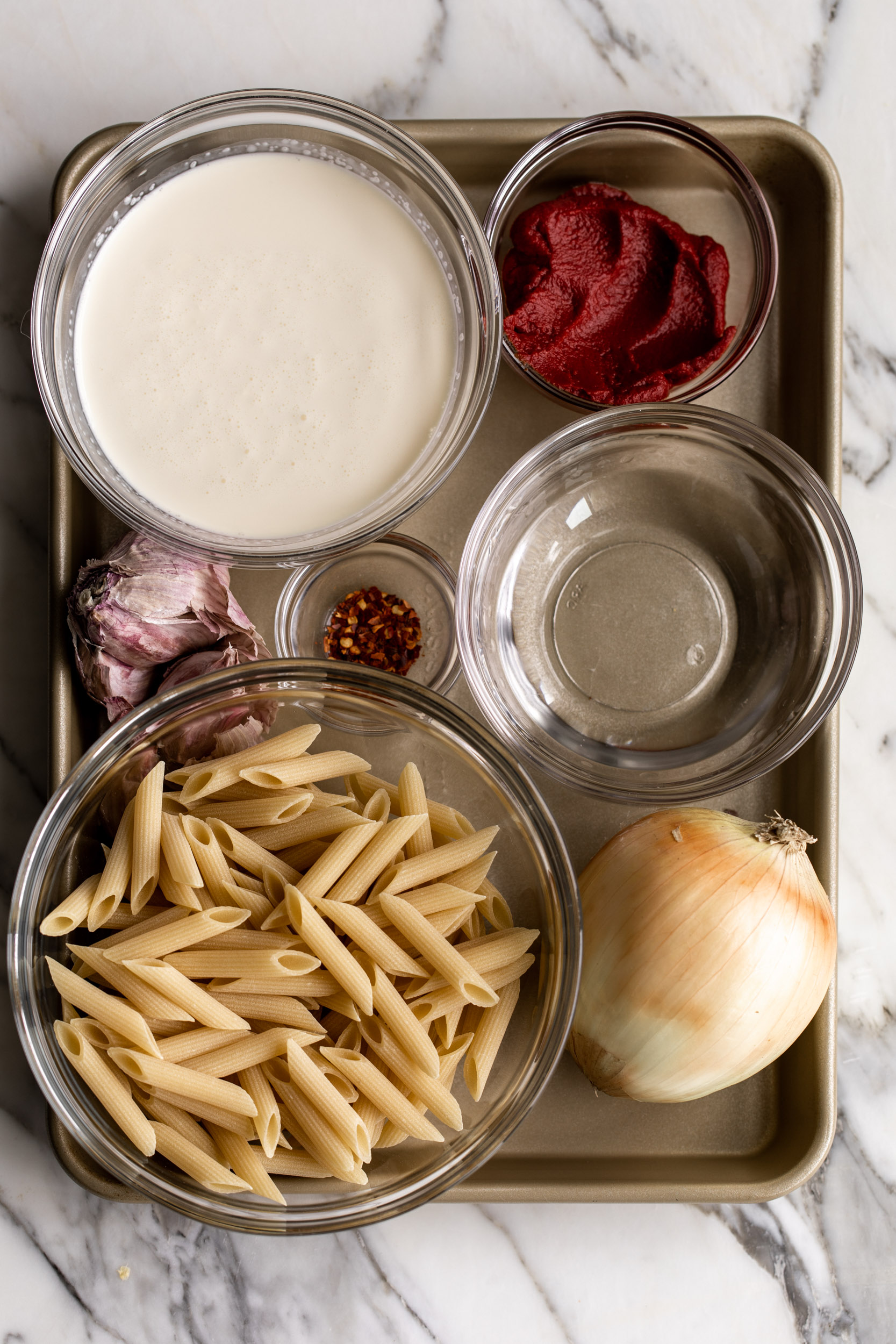 Penne alla Vodka ingredients with onion garlic red pepper cream and tomato paste.