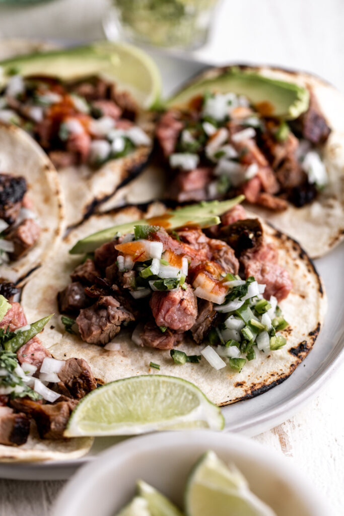 Tri-tip steak marinated in a chili mixture served grilled and sliced as tacos with simple onion salsa and avocado. 