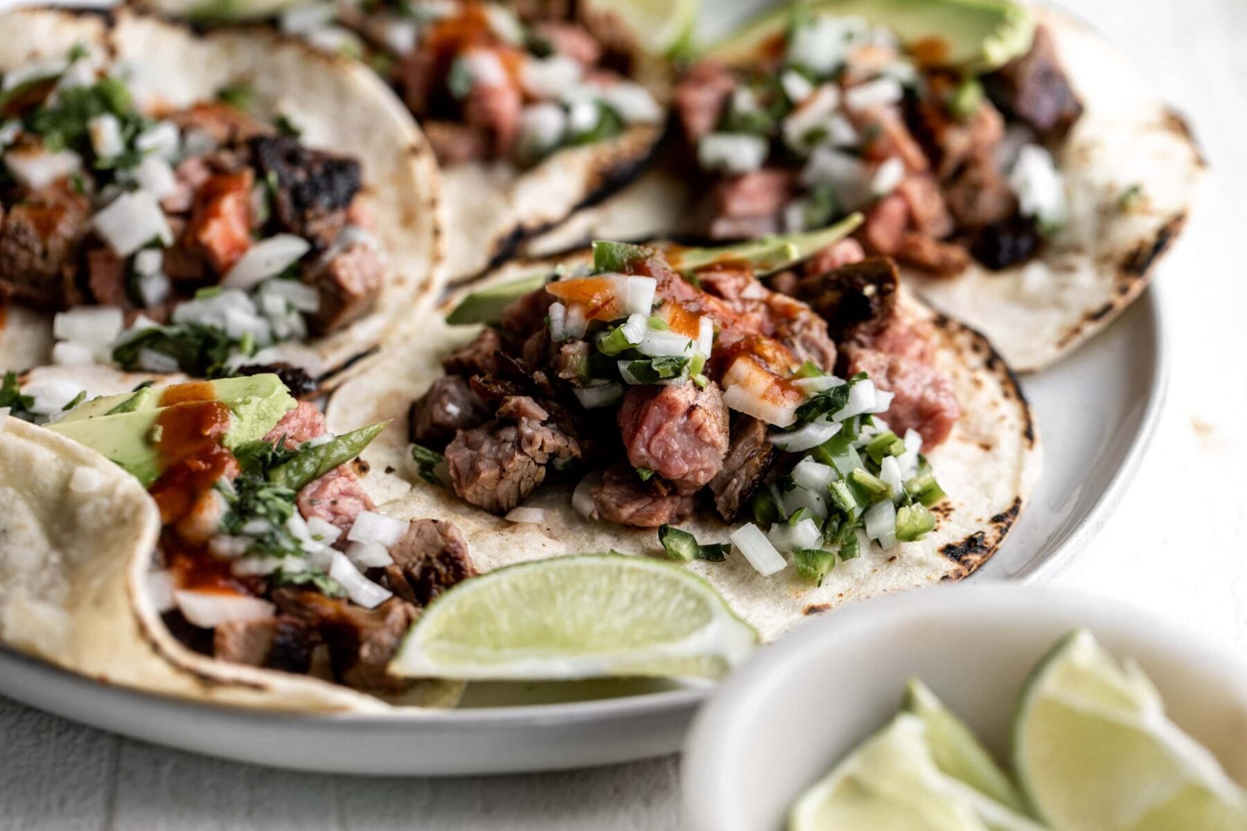 adobada tri-tip sliced served as tacos with avocado, onion and cilantro.