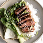 New Zealand beef miso marinated ribeye over white rice with bok choy in bowl
