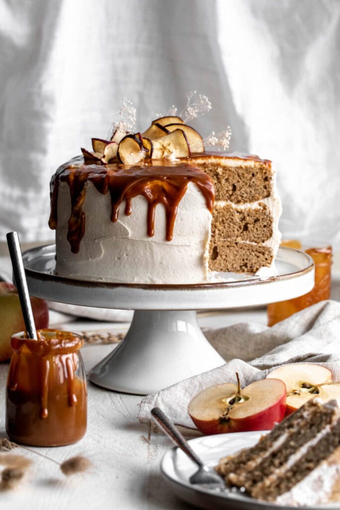 apple cake with slice cut out and decorative dried apples on top.