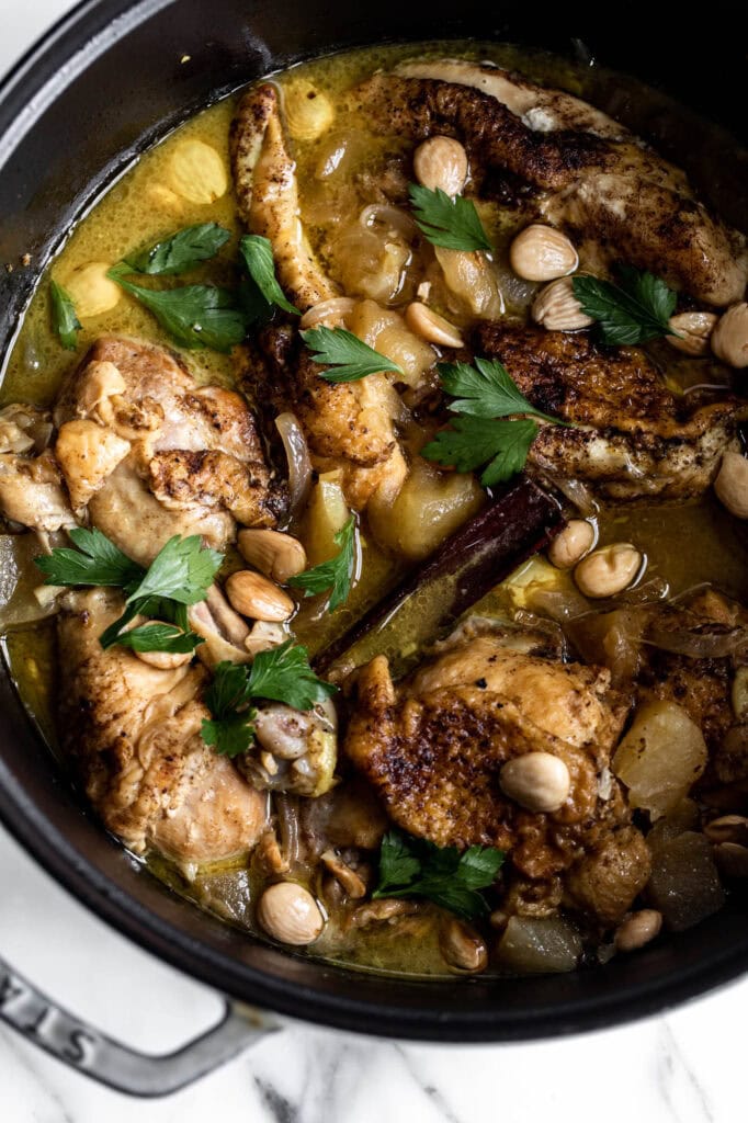 braised moroccan chicken tagine with apples and cinnamon in Dutch oven.