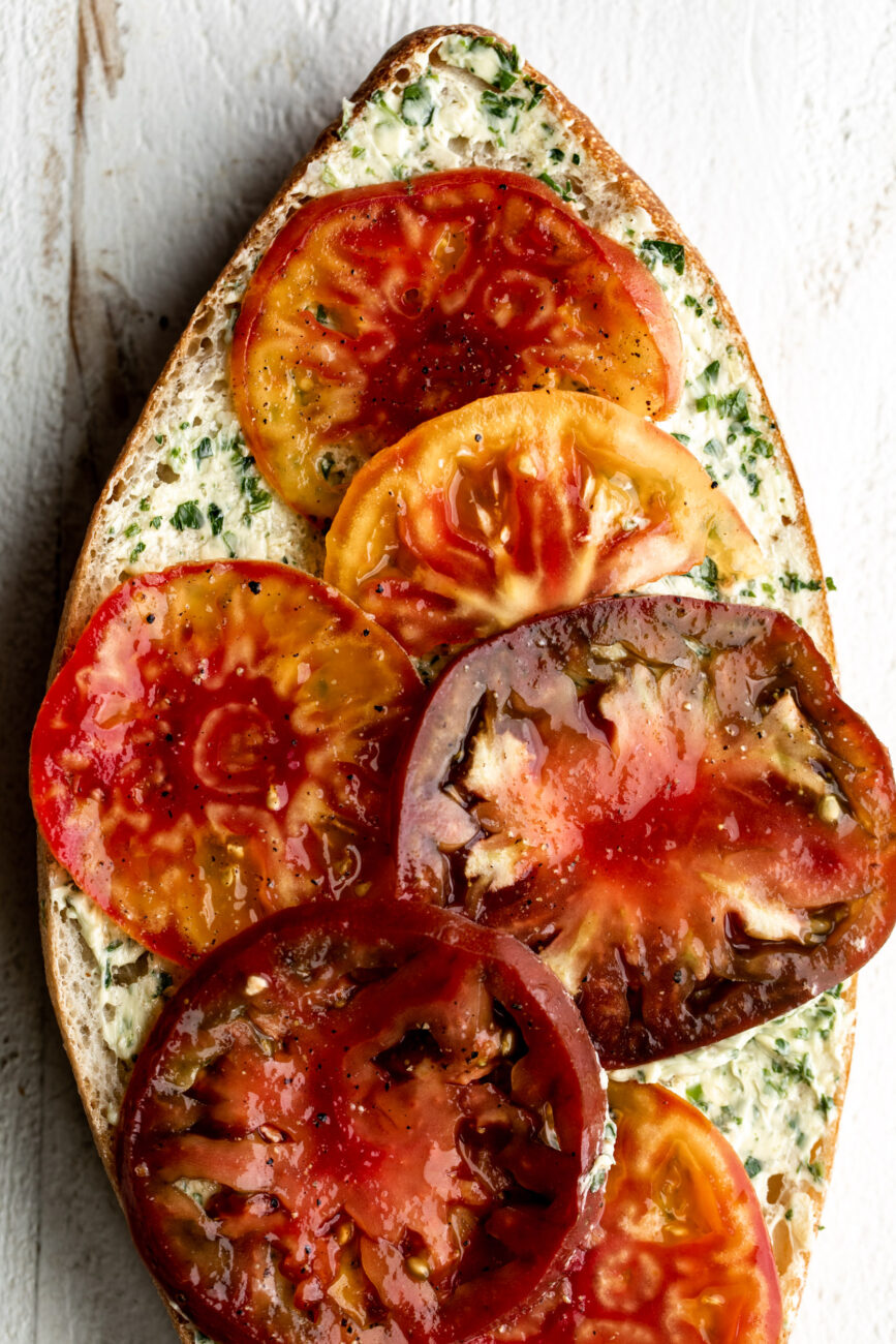 bread loaf topped with slices of tomatoes.