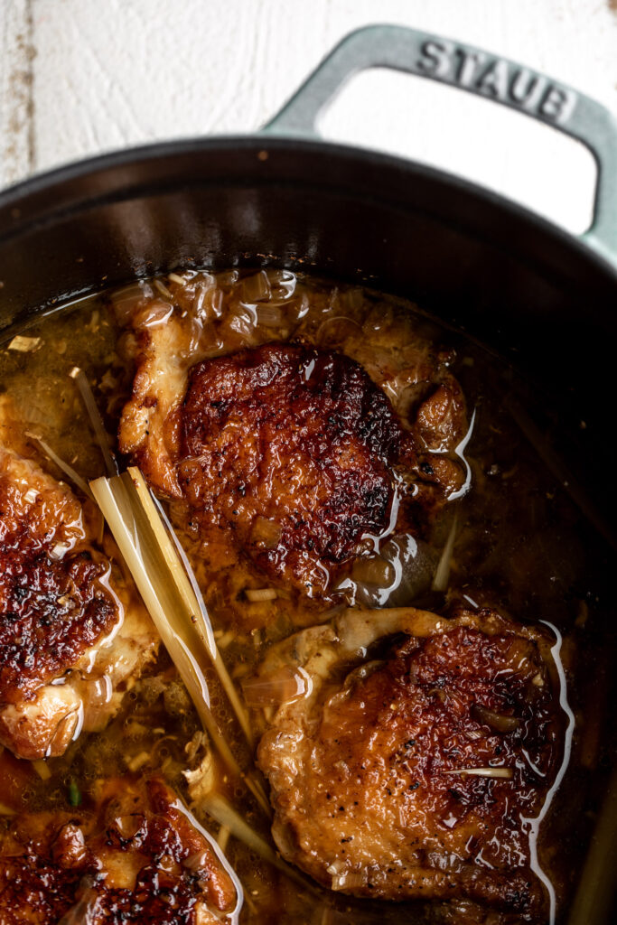braised skin on, bone in chicken thighs in a lemongrass infused broth in a staub dutch oven