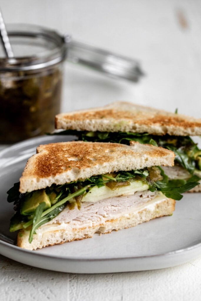 turkey and hatch pepper apple chutney on white bread with arugula.