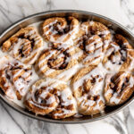apple cinnamon rolls with icing in a oval baking dish