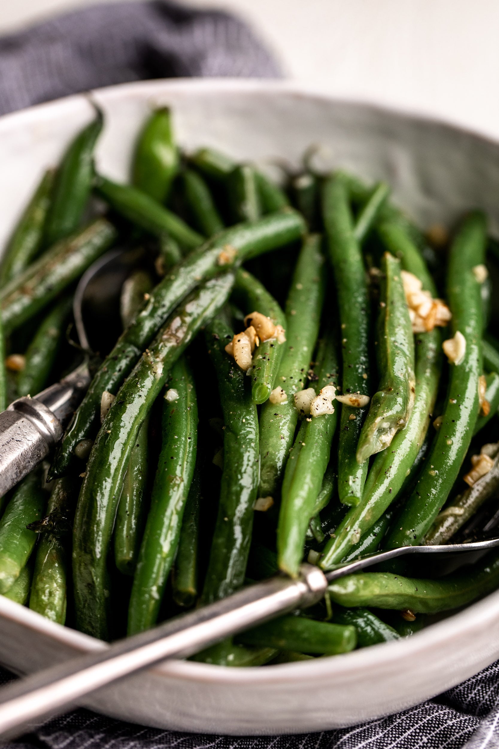 green beans in bowl topped with garlic.