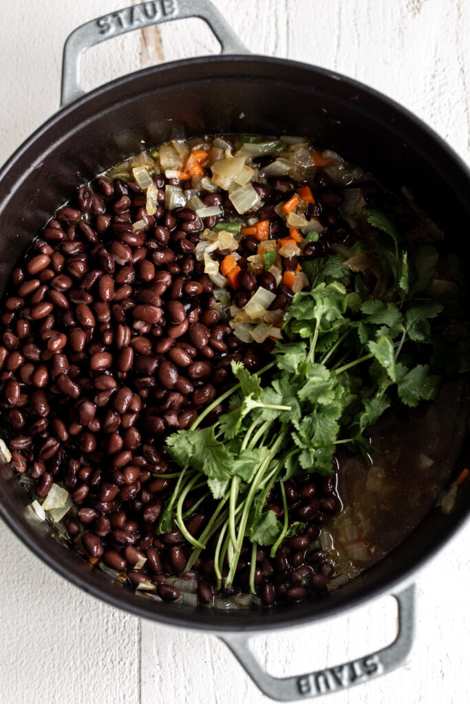 simmer black bean soup in pot with cilantro