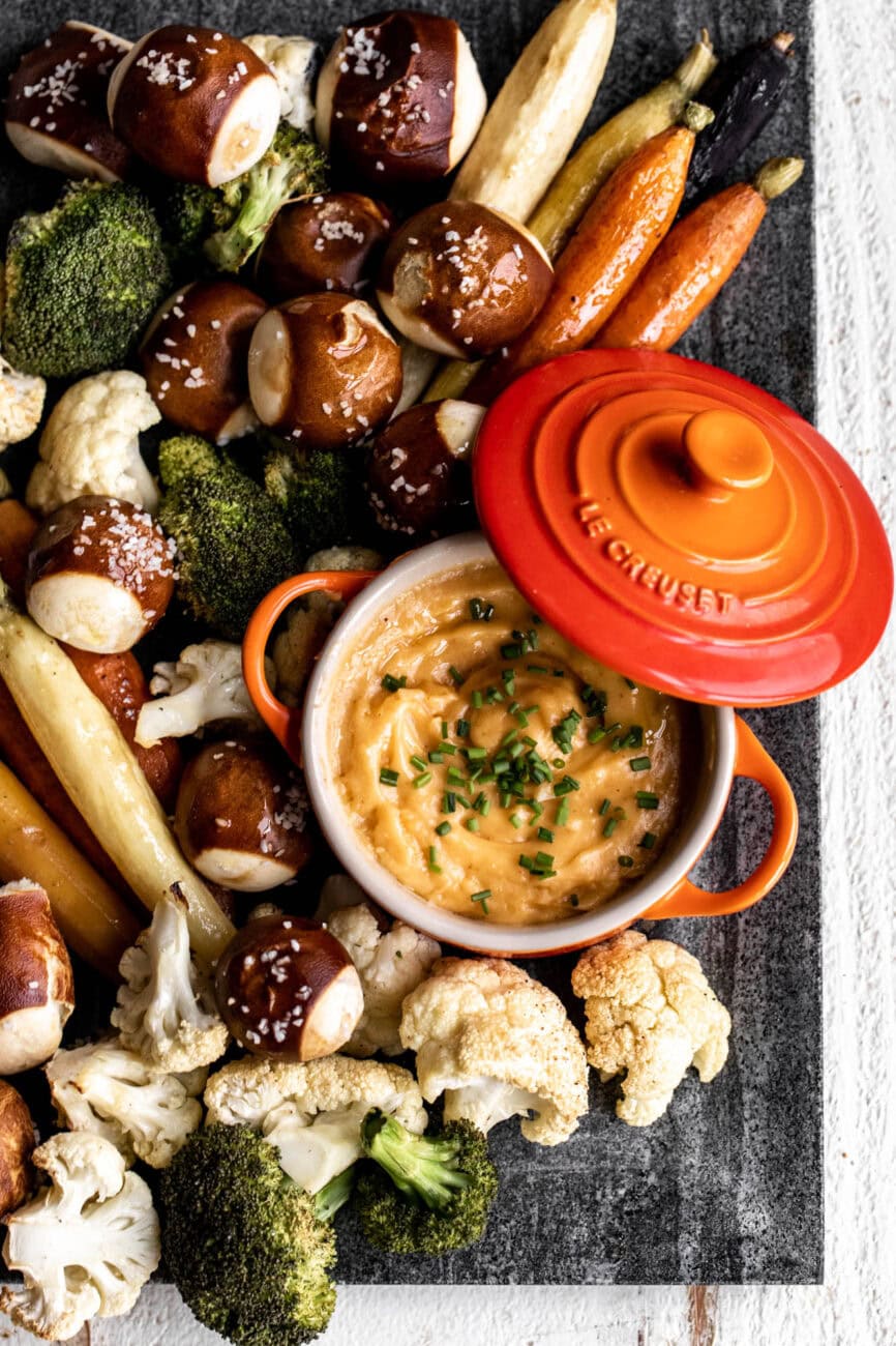 beer cheese fondue with roasted vegetables and pretzel bites.