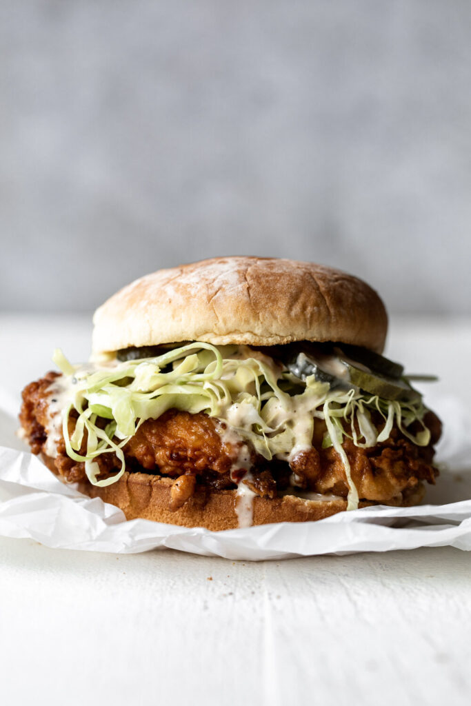 fried chicken sandwich with Alabama white sauce, slaw and pickles on potato bun