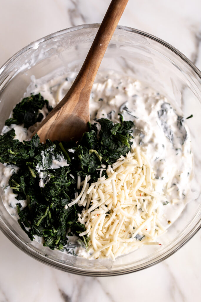 cream cheese half and half with spinach and cheese in mixing bowl