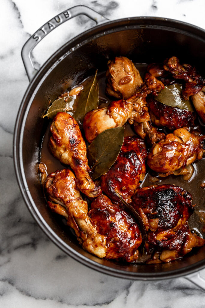 filipino chicken adobo in dutch oven with bay leaves