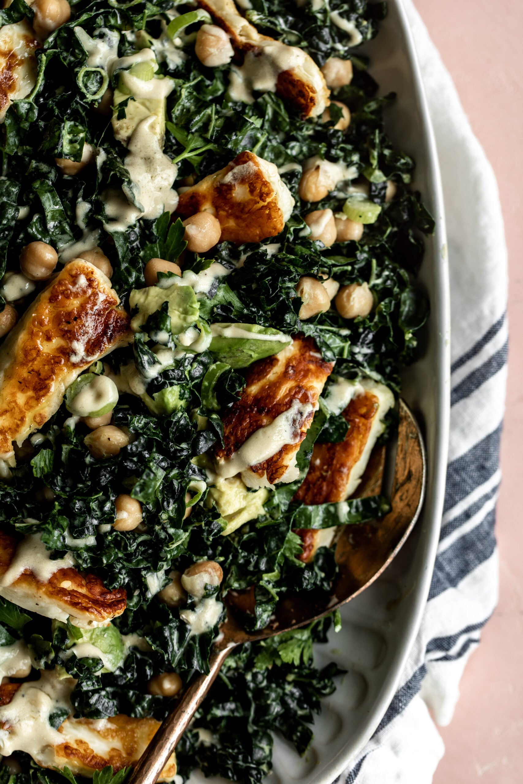 Crispy Halloumi kale salad with garlic tahini dressing on a serving platter.