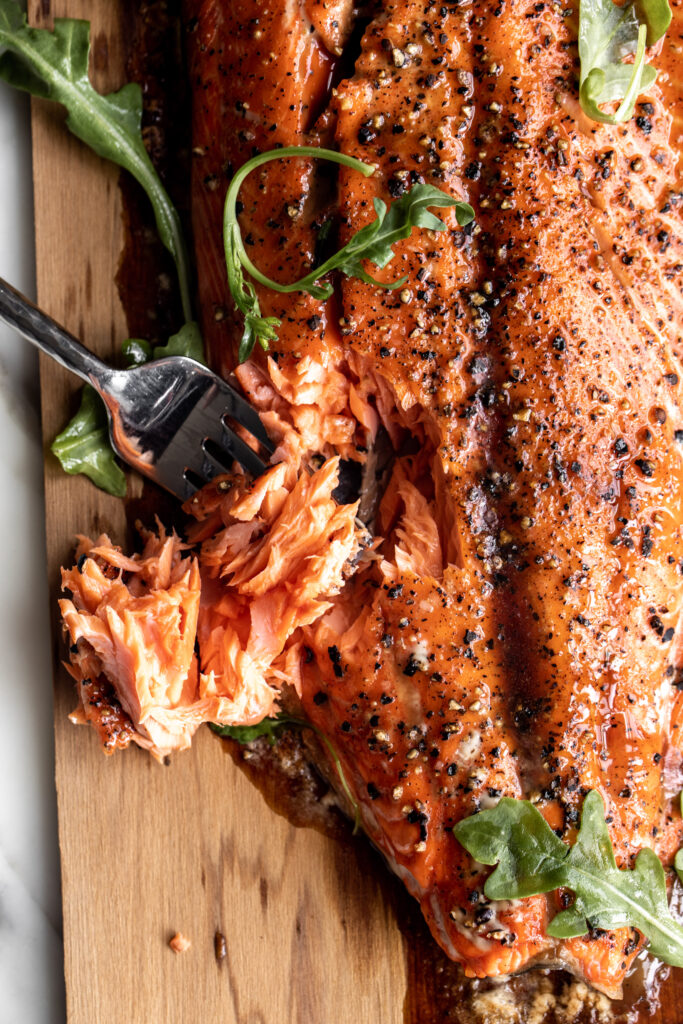 Cedar Plank Salmon with Brown Sugar & Black Pepper flaked with a fork