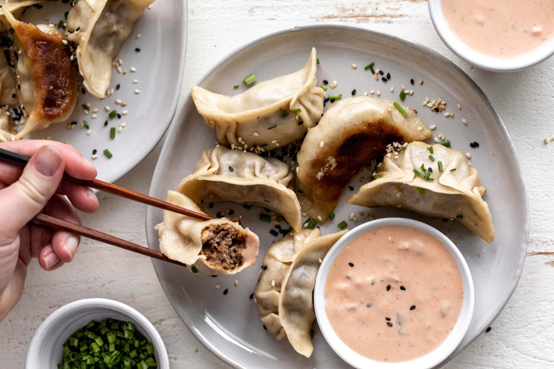 cheeseburger dumplings with chopsticks.