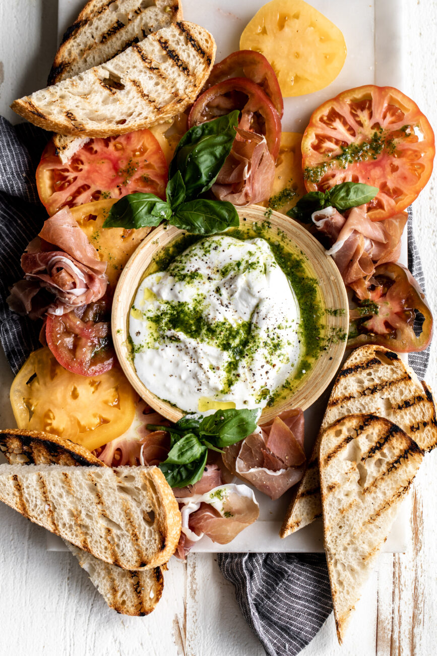 heirloom tomato, prosciutto and burrata with garlic basil oil and grilled bread.