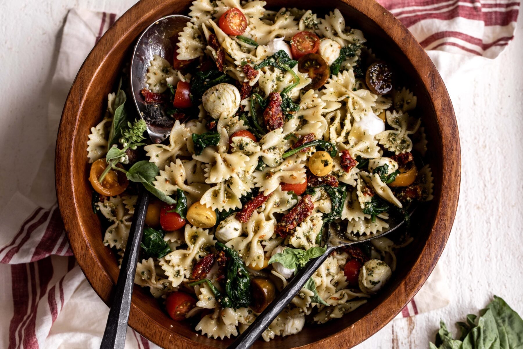 Pesto Pasta Salad Recipe in wooden mixing bowl.