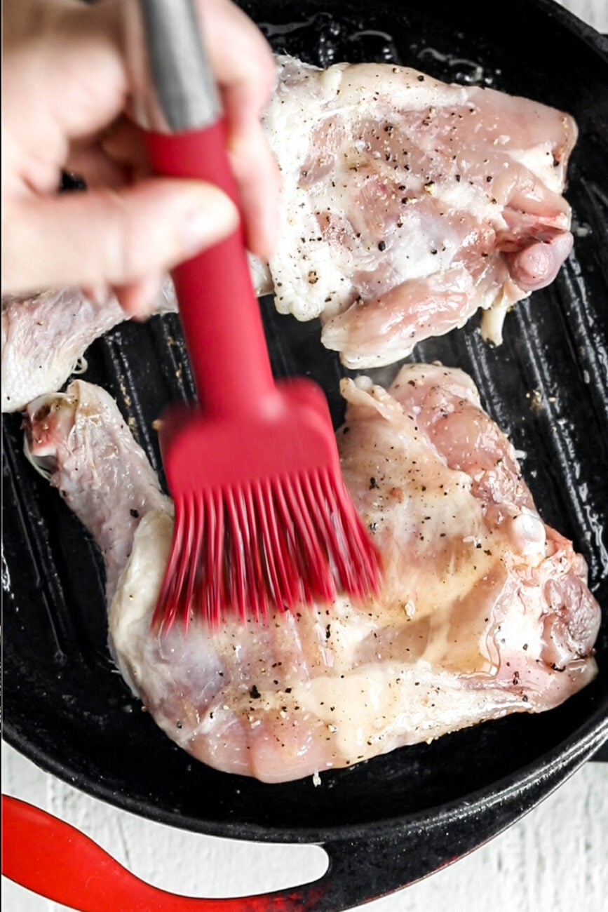 brushing the sauce on the chicken.