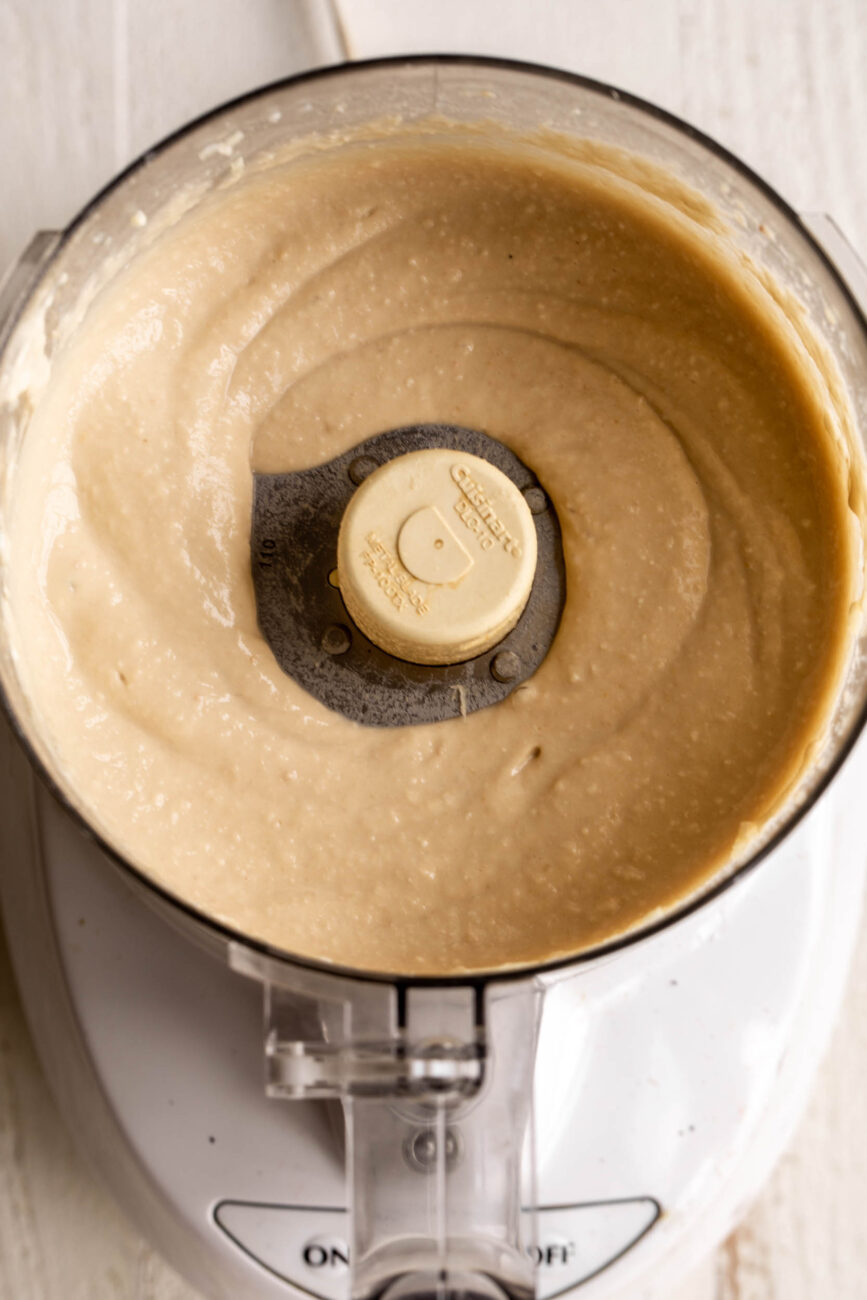 creamy blended hummus in food processor.
