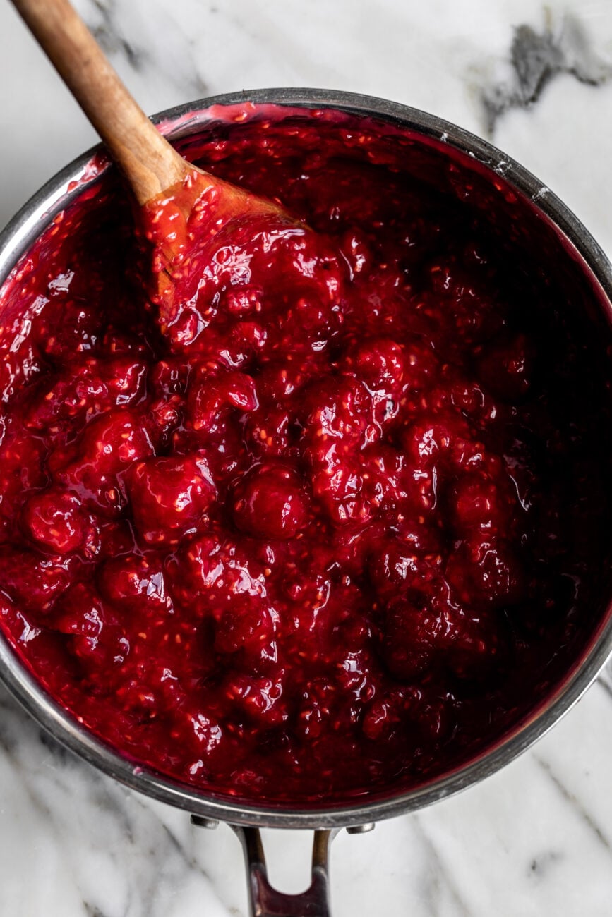 raspberry pie filling with wooden spoon.