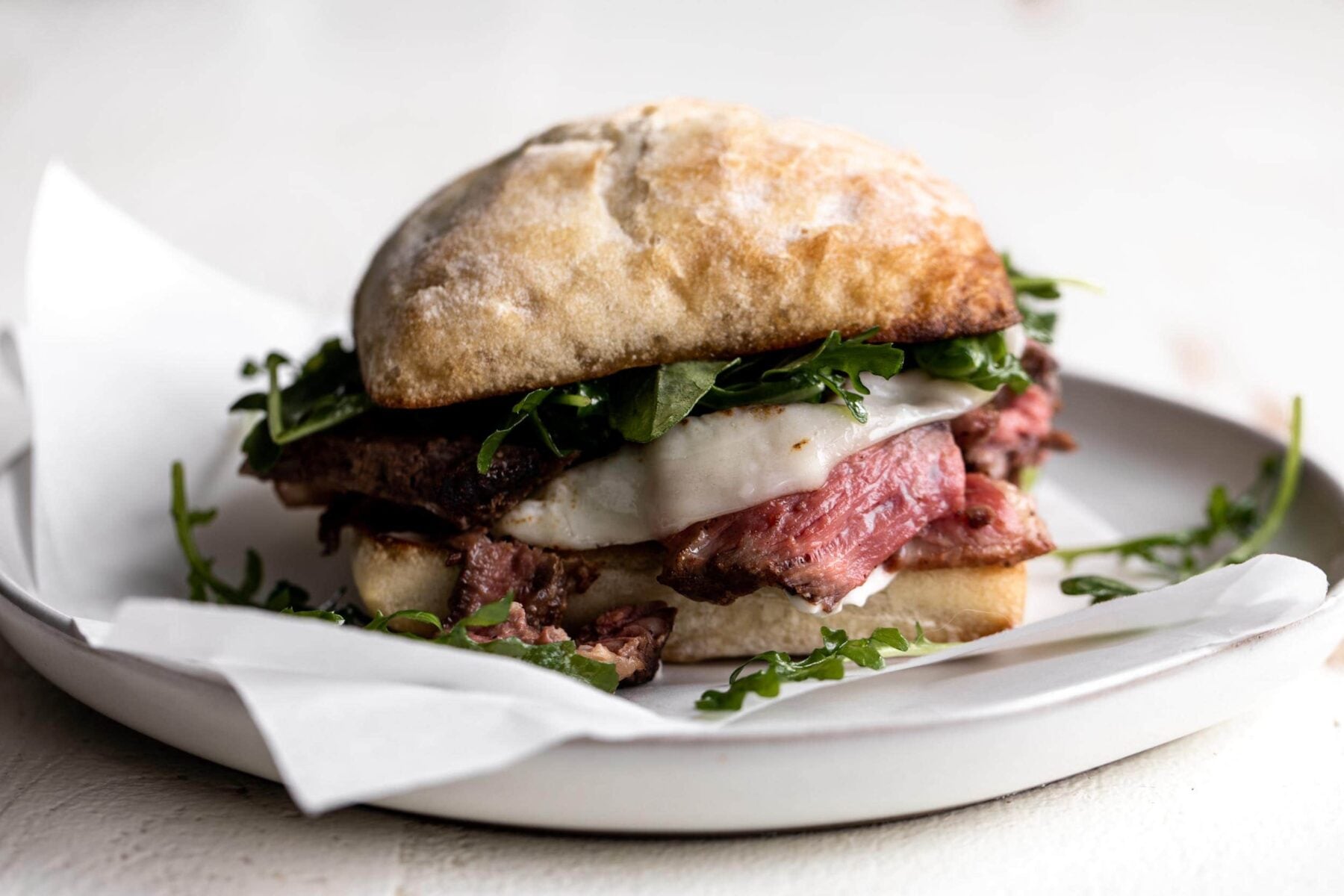 ribeye steak sandwich with horseradish mayonnaise and arugula.