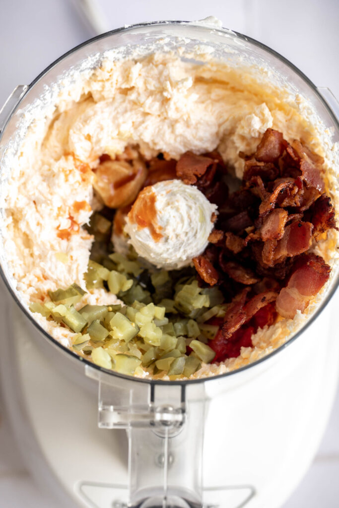 ingredients in food processor with bacon pickles and pimento peppers