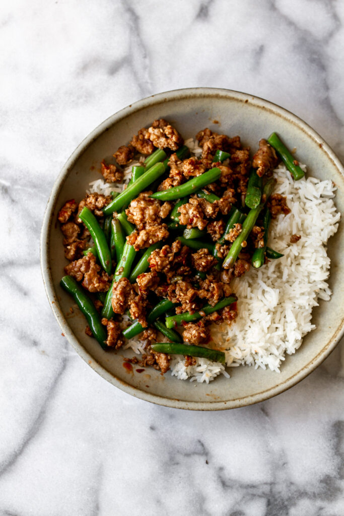 sichuan pan-fried green beans with ground pork over white rice