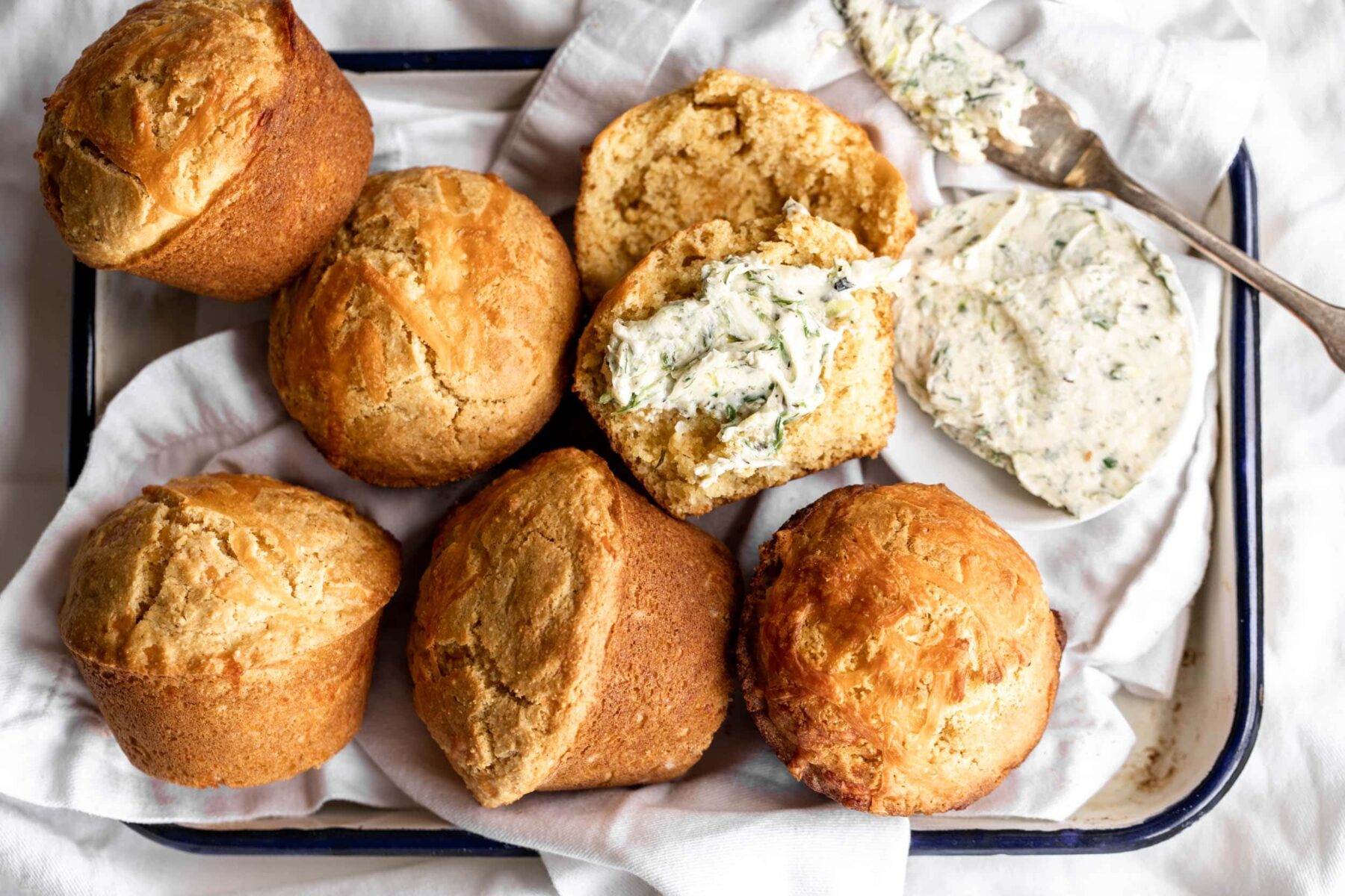Cheddar corn muffins with charred scallion butter spread on muffins.