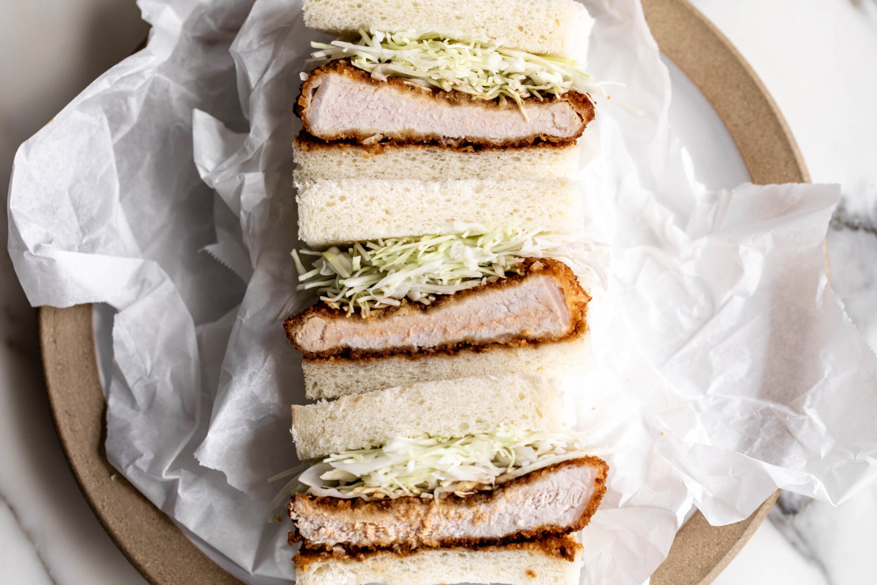 Crispy pork katsu sandwich with shredded cabbage and tonkatsu sauce.