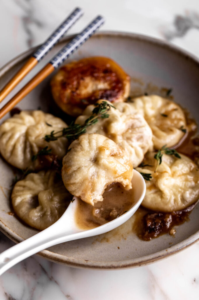 French onion soup dumplings with spoon and thyme