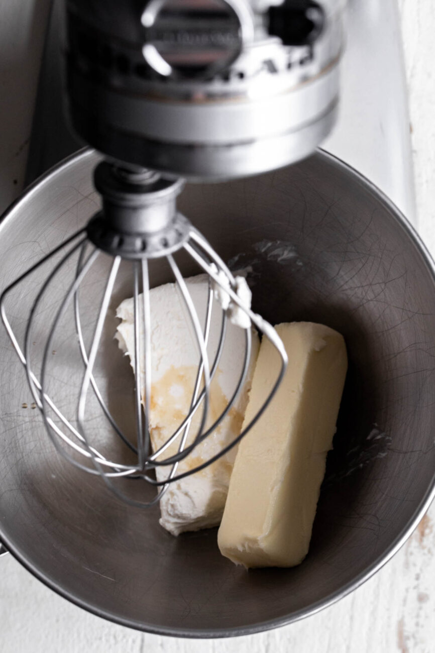 cream cheese frosting ingredients in stand mixer butter and cream cheese block.