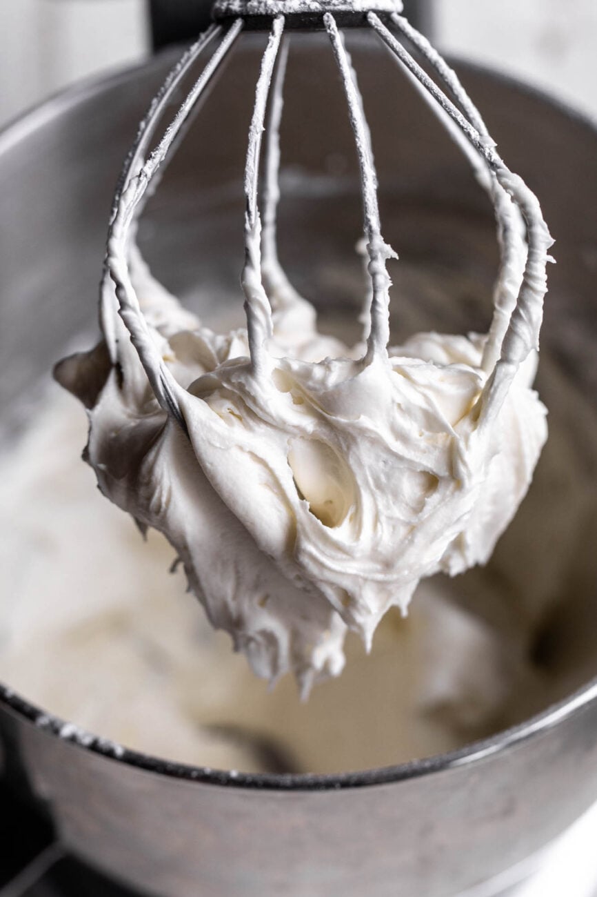 cream cheese frosting on whisk of stand mixer.