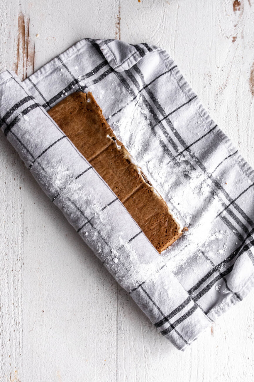 pumpkin sponge cake rolled in prepared tea towel.
