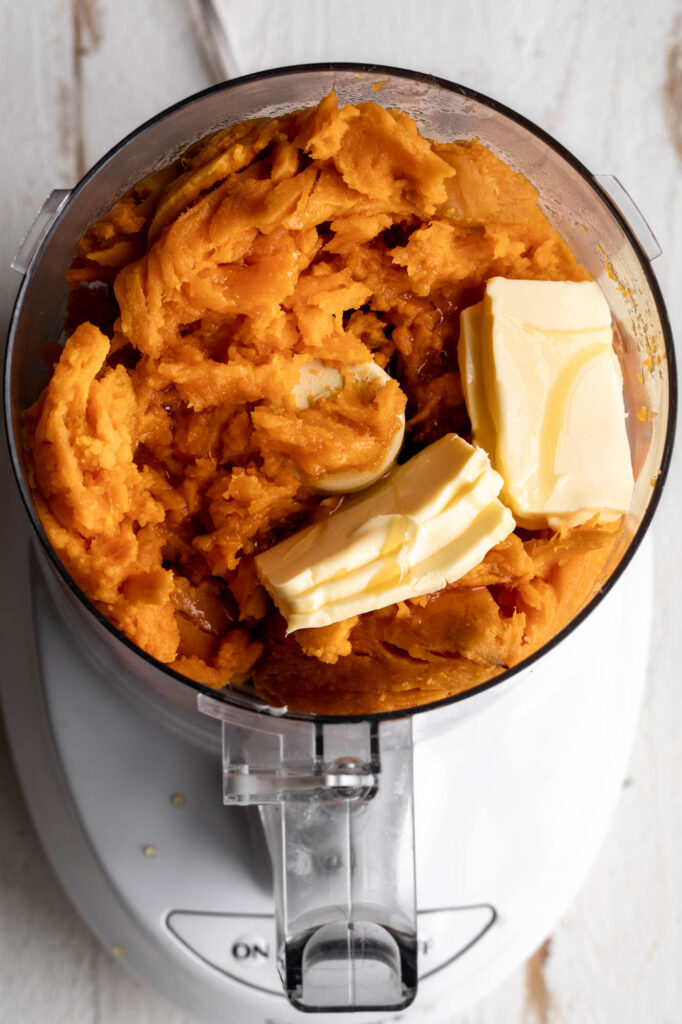 mashed sweet potatoes in food processor with honey and butter