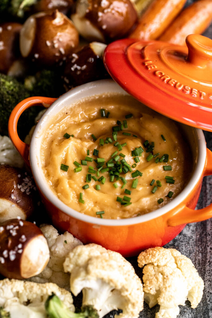 closeup beer cheese fondue in le creuset cocotte pot