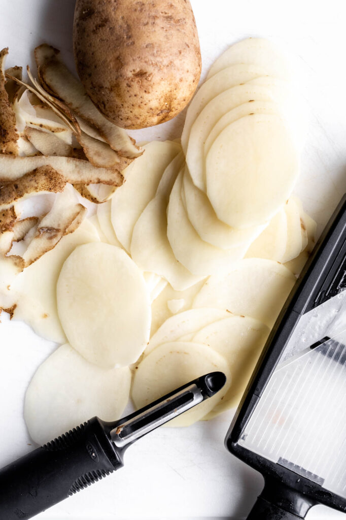 thinly sliced potatoes on a mandolin