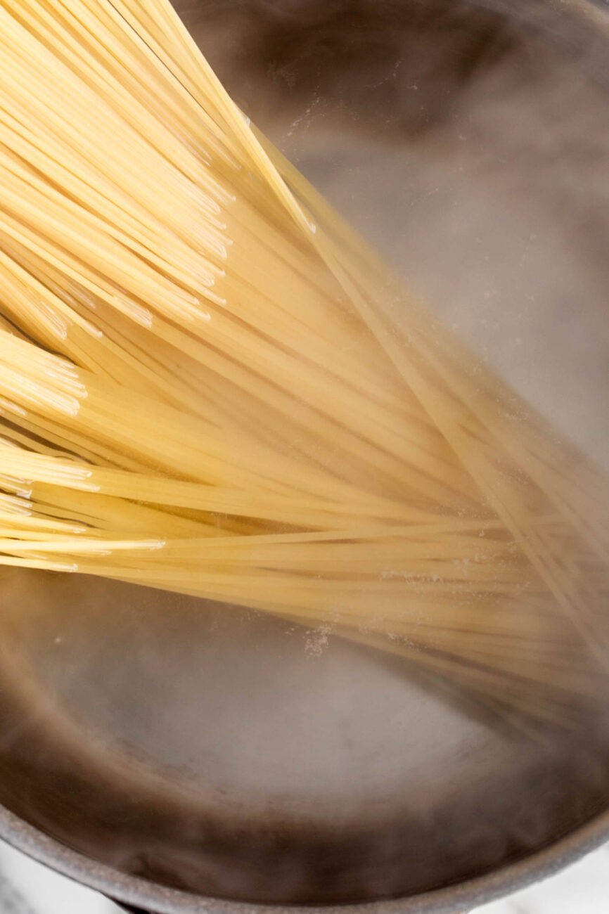 cooking spaghetti noodles in pot.