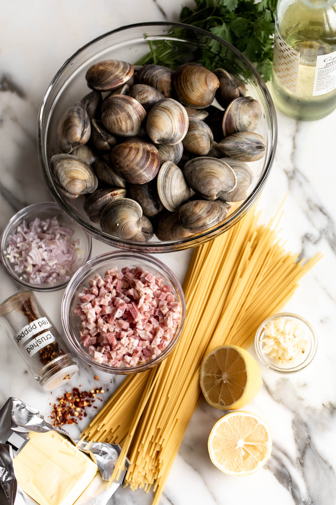 ingredients for spaghetti alle vongole laid out clams in bowl and dried spaghetti.