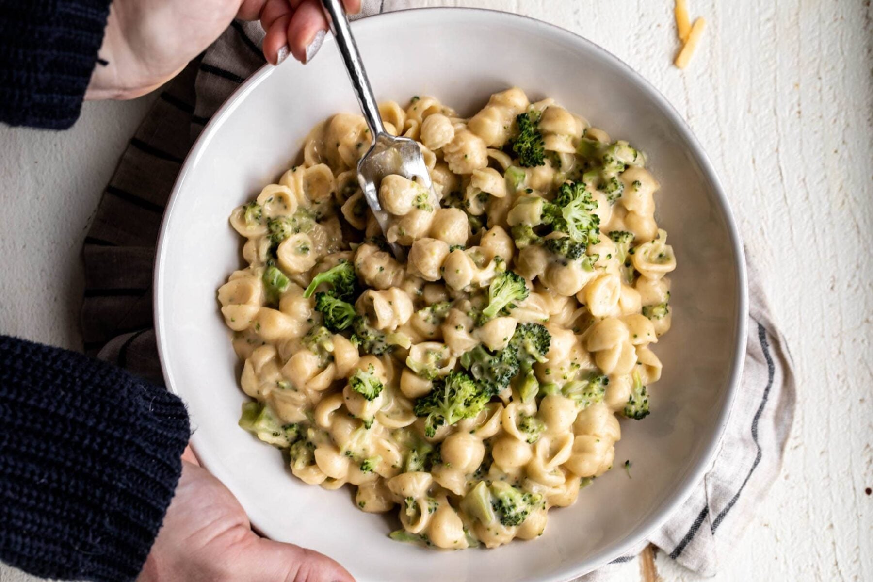 broccoli cheddar mac and cheese in white bowl.