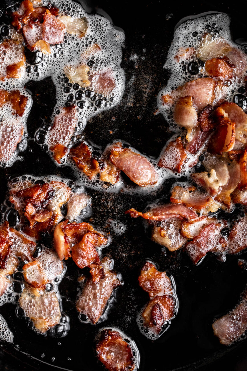 sliced cooked bacon in pan.