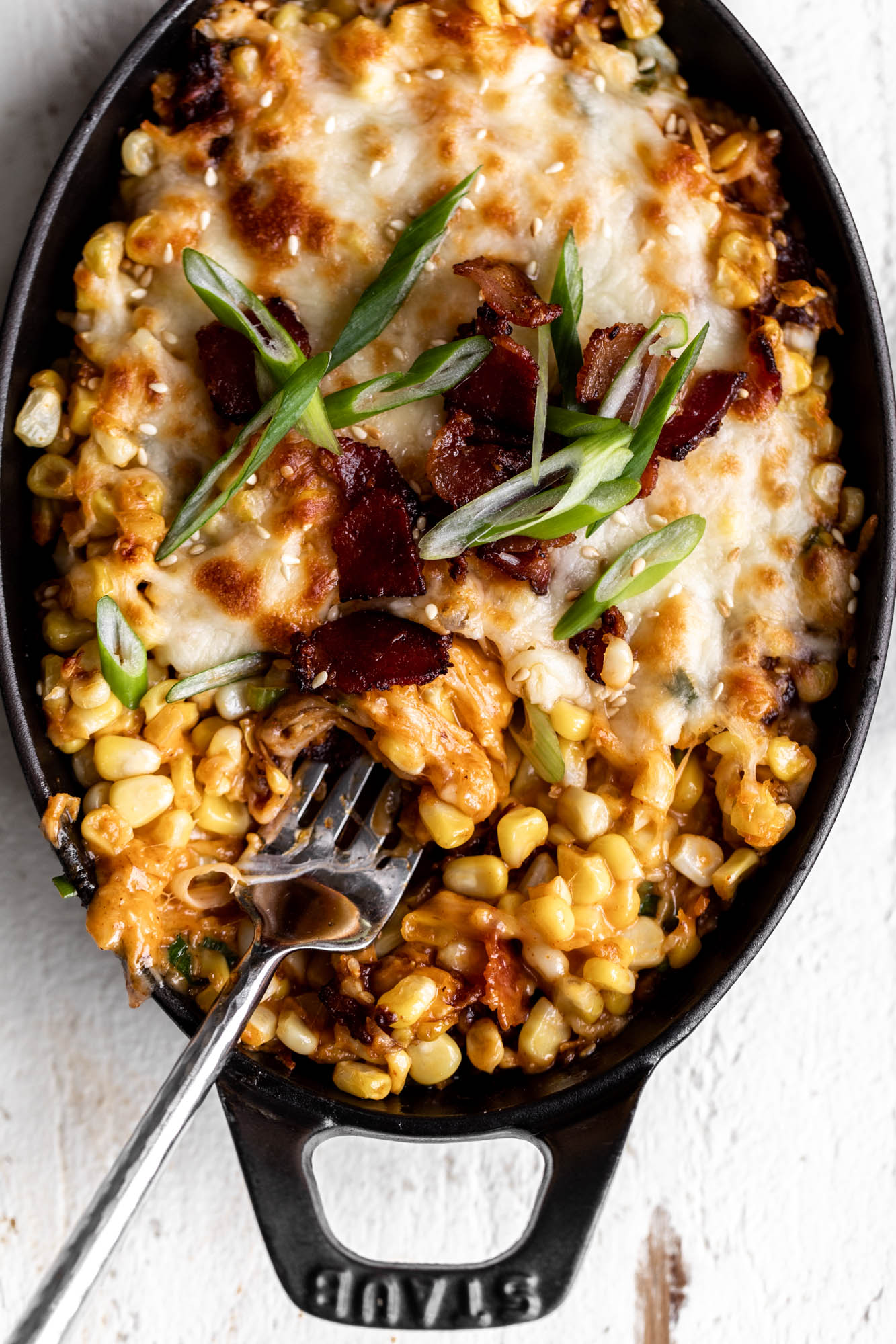 korean spicy cheesy corn with bacon in small serving dish.