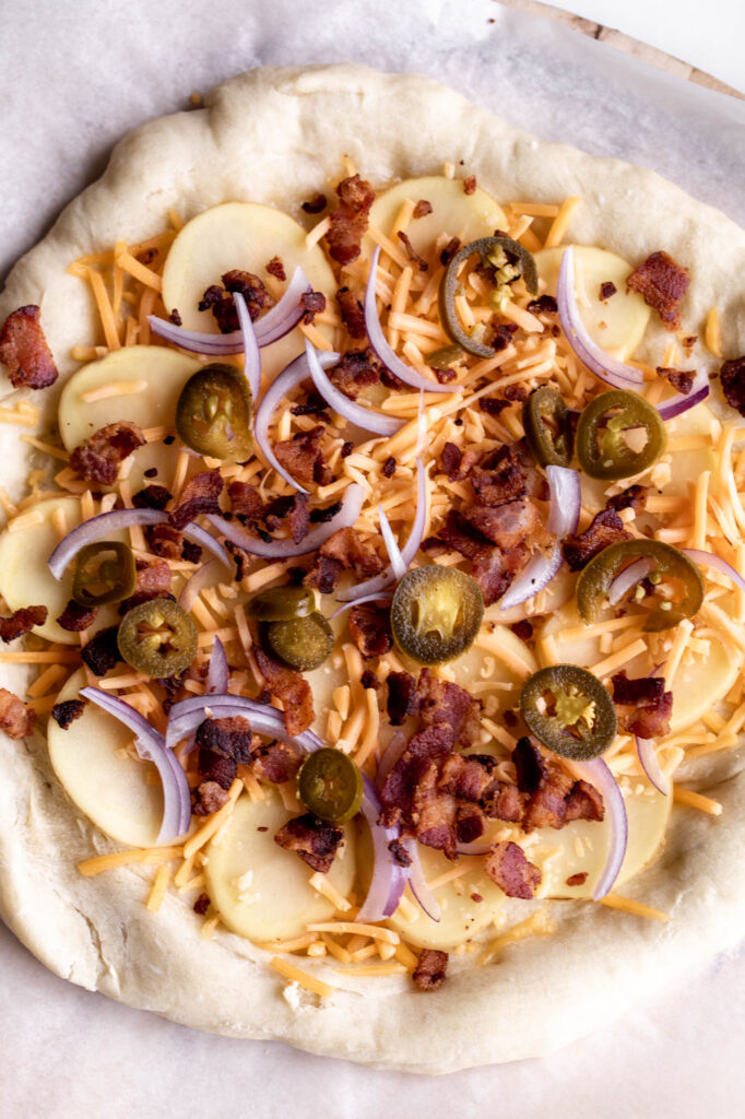 dough with toppings for Baked Potato Pizza 