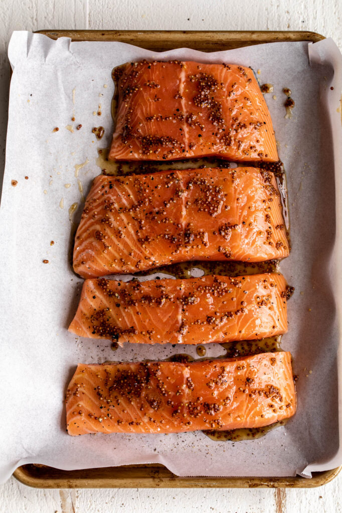 uncooked maple mustard salmon on a baking sheet