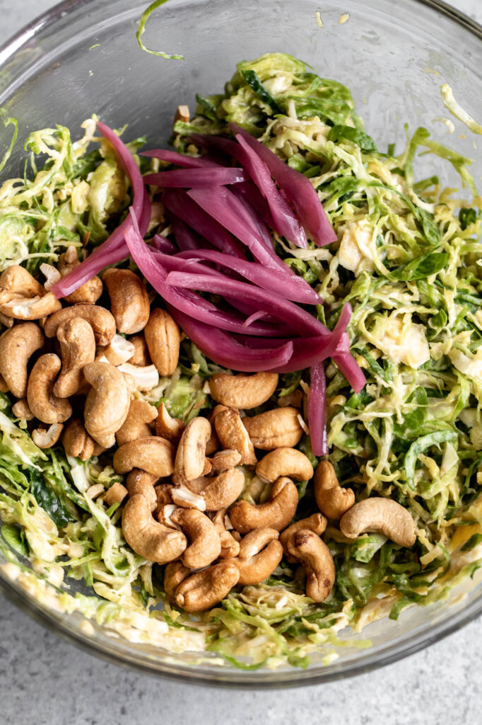 shredded brussels sprouts salad with cashew and onions