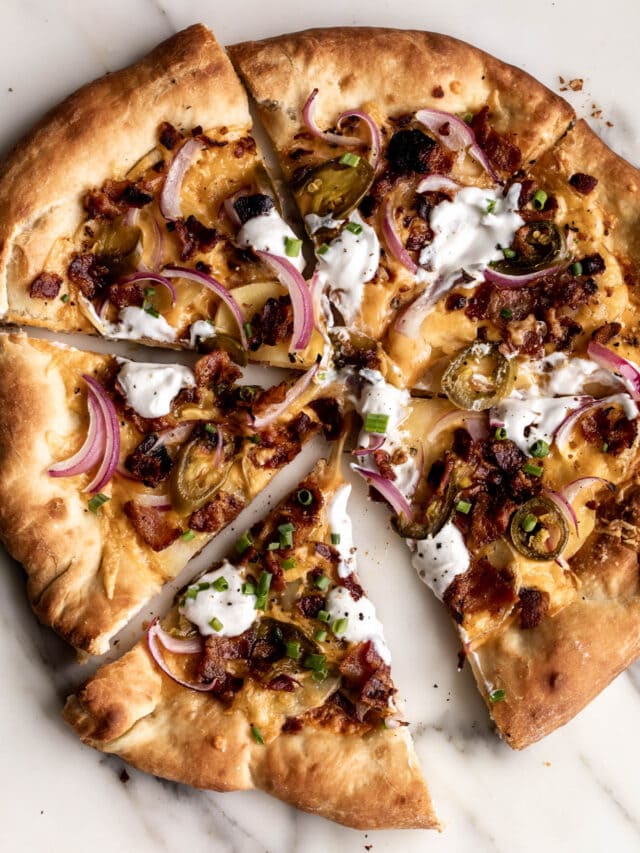 Loaded baked potato pizza with thinly shaved potato slices, bacon, red onion, cheddar cheese, & pickled jalapeños. add dollops of sour cream & diced chives. white pizza made without tomato sauce